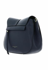 Sac à épaule en cuir bleu marine avec une forme arrondie, fermeture à rabat et logo doré. Surface texturée et bandoulière réglable.