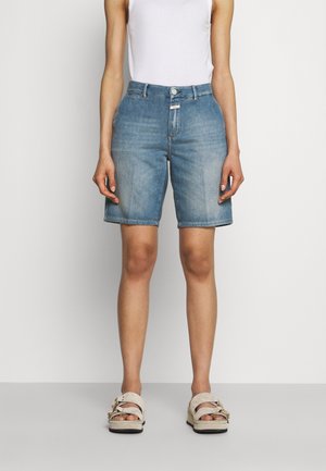 Denim shorts in light blue, mid-thigh length, with a straight cut. Features a button and zipper closure, five pockets, and subtle fading.