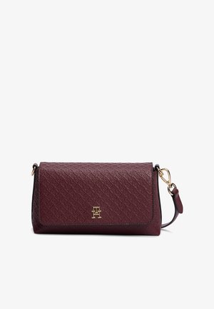 Μπορντό δερμάτινο clutch με υφή, με χρυσό λογότυπο TH και αποσπώμενο λουράκι με χρυσά μεταλλικά στοιχεία σε λευκό φόντο.