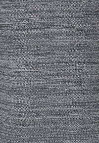 Tissu tricoté avec une surface texturée dans des tons bleu foncé et gris clair, présentant des rayures horizontales et des motifs côtelés sur toute la surface.