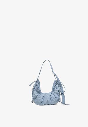Sac d’épaule en tissu doux bleu clair avec un design froncé, une bandoulière réglable et un petit logo circulaire sur un côté, sur fond blanc.