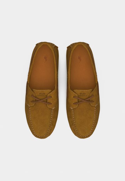 Καφέ σουέτ μοκασίνια ανδρικά loafers με δερμάτινα κορδόνια και ραμμένες λεπτομέρειες, σε θέα από πάνω σε φωτεινό φόντο.