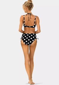 Czarny i biały bikini w groszki z gorsecikiem na Halter i wysokim stanem. Regulowane wiązania po bokach oraz zapięcie na plecach.