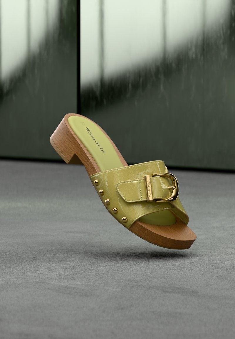 Sandale à glissière en cuir verni vert citron avec une large bride, une boucle dorée et des accents cloutés sur le côté. Talon en bois et semelle texturée.