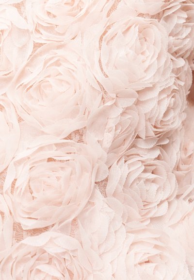 Ελαφρύ ροζ ύφασμα με υφή που διακοσμείται με στρωματοποιημένα, τρισδιάστατα μοτίβα τριαντάφυλλων από απαλό, ευαίσθητο υλικό.