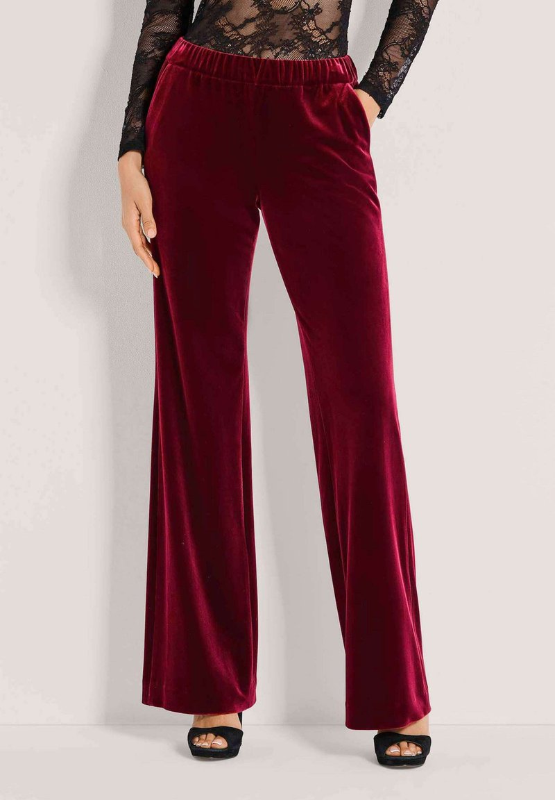 Bordeaux fluwelen flared broek met een elastische tailleband en zijzakken, met een gladde textuur en een wijd ontwerp.