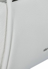 Borsa a mano bianca in pelle con finitura testurizzata, cinturino sottile e dettaglio del logo metallico nella parte inferiore. Inquadratura obliqua focalizzata sul materiale.