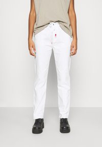 Witte katoenen broek met een relaxed fit, een koord in de taille en zijzakken. Gecombineerd met zwarte veterschoenen.