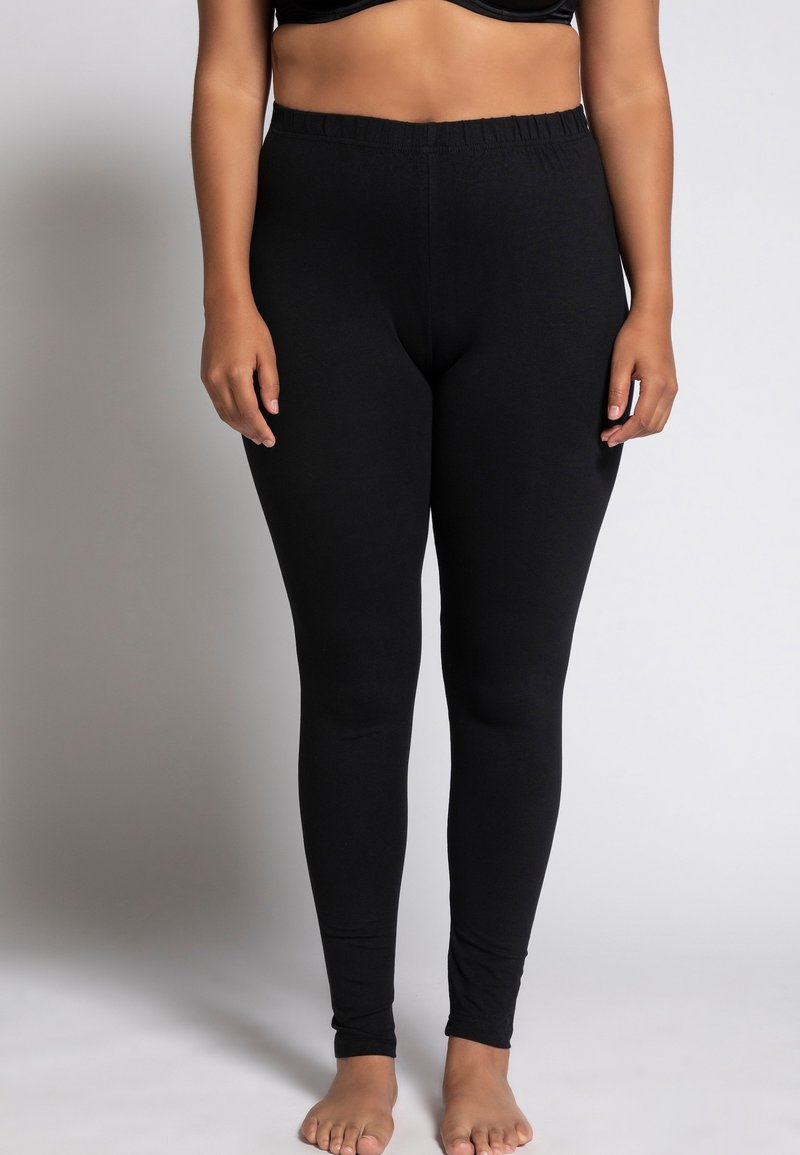 Leggings neri realizzati in un materiale morbido e elasticizzato, con una vita elasticizzata, design aderente e texture liscia e uniforme.
