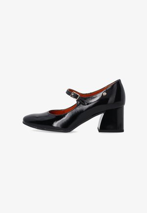 Black patent leather Mary Jane shoes with a rounded toe, adjustable ankle strap, and a block heel, featuring a metallic accent.