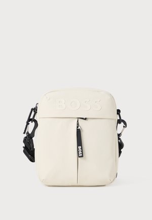 Bolsa crossbody na cor bétula com logotipo em relevo, fecho com zipper, alça ajustável e detalhe de costura frontal discreto. Feita de material durável.