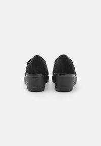 Zwarte suede instapschoenen met een blokhak, voorzien van een gladde textuur en een subtiele GEOX-logo op de hiel.