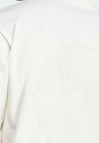 Sudadera de algodón blanca con un sutil diseño en relieve de un mapa o globo en la parte trasera, con una textura suave y un ajuste casual.