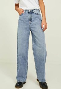 Jeans azzurri a vita alta con una vestibilità rilassata e gambe larghe. Realizzati in denim, con chiusura frontale a bottone e tasche laterali.