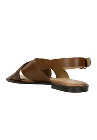 Brown leather sandal with open toe, cross-strap design, and a back strap. Flat sole with textured insole and minimal hardware accents.