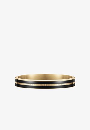 Zlata in črna zapestnica s sijajno površino, ki ima ozko črno črto in vgraviran poudarek "DANIEL WELLINGTON".