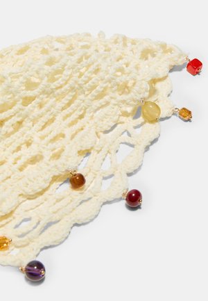 Krémová háčkovaná látka s vlnitým okrajom zdobená malými, viacfarebnými korálikmi v červenej, žltej, hnedej a fialovej farbe.