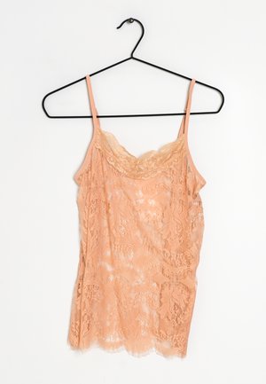 Peach lace camisole with thin straps, featuring floral patterns, scalloped edges, and a sheer texture. Hangs on a black metal hanger.