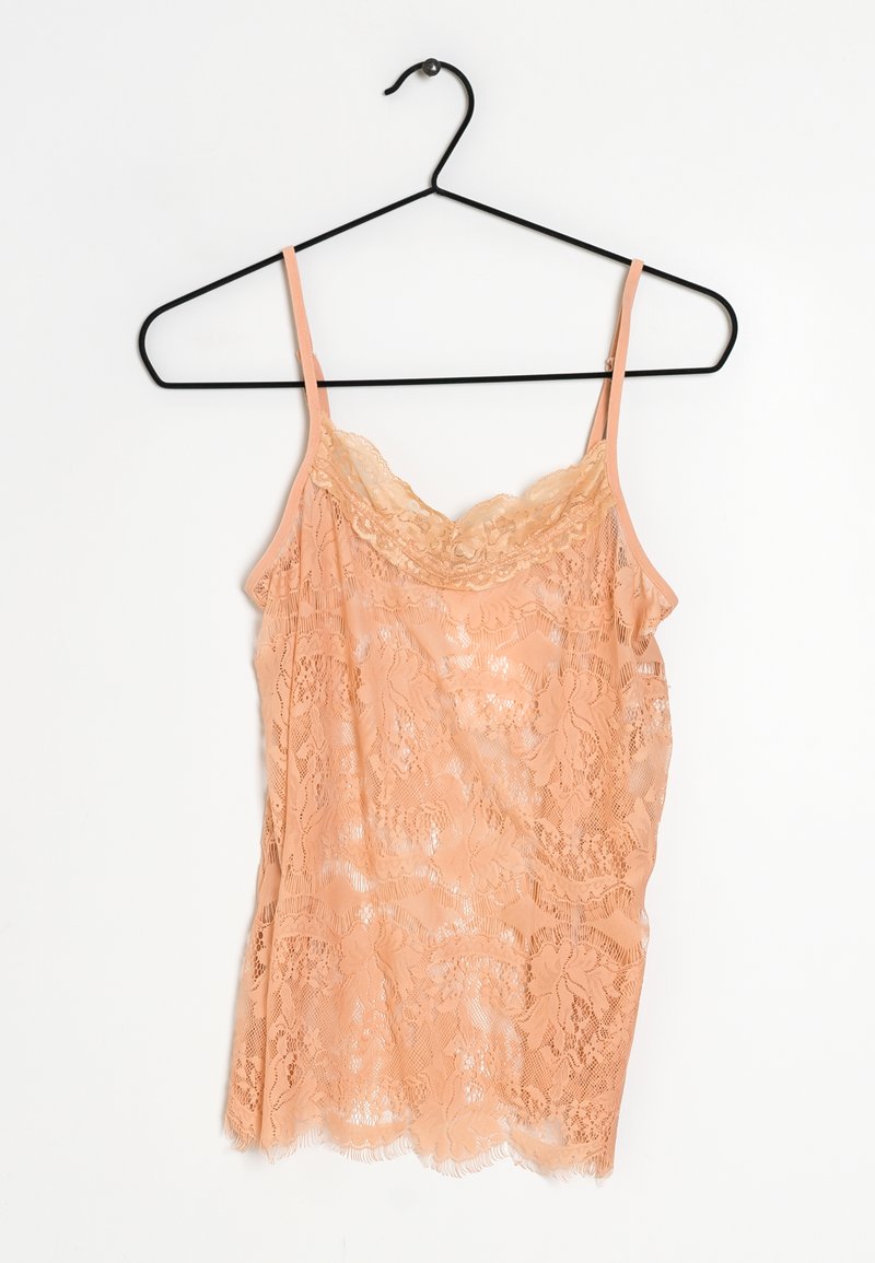 Peach lace camisole with thin straps, featuring floral patterns, scalloped edges, and a sheer texture. Hangs on a black metal hanger.