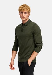 Grünes gestricktes Poloshirt mit Kragen, drei-Knopf-Leiste und langen Ärmeln. Der Stoff wirkt weich und strukturiert.