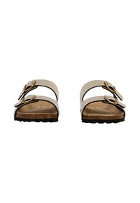 White leather sandals with two adjustable straps, gold buckles, and a cork footbed. Textured black rubber sole. Flat design.