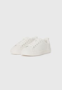 Białe sneakersy z gładką syntetyczną cholewką, okrągłym noskiem i pięcioma oczkami na sznurówki. Posiadają subtelne perforacje i teksturowaną gumową podeszwę.