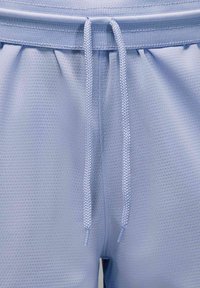 Gaiši zili sporta šorti ar teksturētu audumu, elastīgu jostasvietu un regulējamu sašūtu auklu. Iekšējās kabatas nodrošina ērtību.