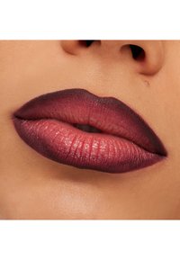 Matte lepper i en gradient fra dyp burgunder til myk rosa, som viser en definert kontur og jevn tekstur med synlige linjer og glans.