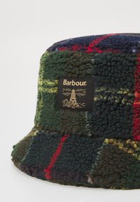 Groene, blauwe en rode geruite emmerhoed van zacht, gestructureerd fleece, met een zwart Barbour-logo op de voorkant.
