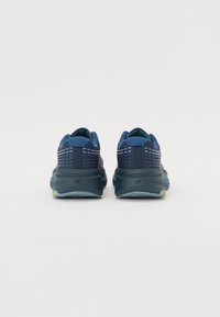 Zapatillas de running en color marino con parte superior de malla texturizada, mediopie amortiguado y suela de goma duradera con un acento amarillo en el talón.