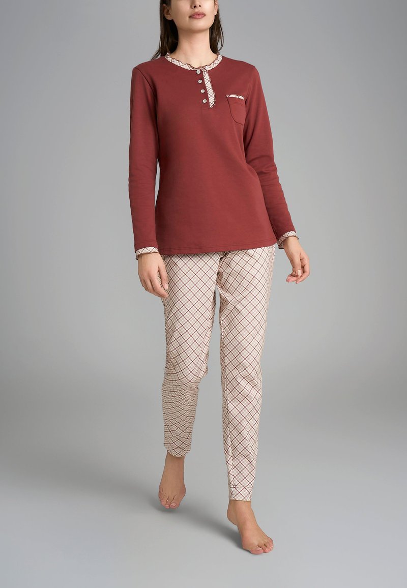 Maglietta a maniche lunghe color marrone bordeaux con bottoni e pantaloni da pyjama crema a scacchi, caratterizzati da un design aderente e una texture morbida.