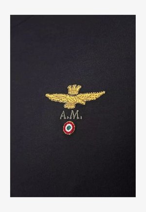 Tessuto blu scuro con un'aquila ricamata in oro e "A.M." sopra un design circolare in rosso, bianco e verde al centro.