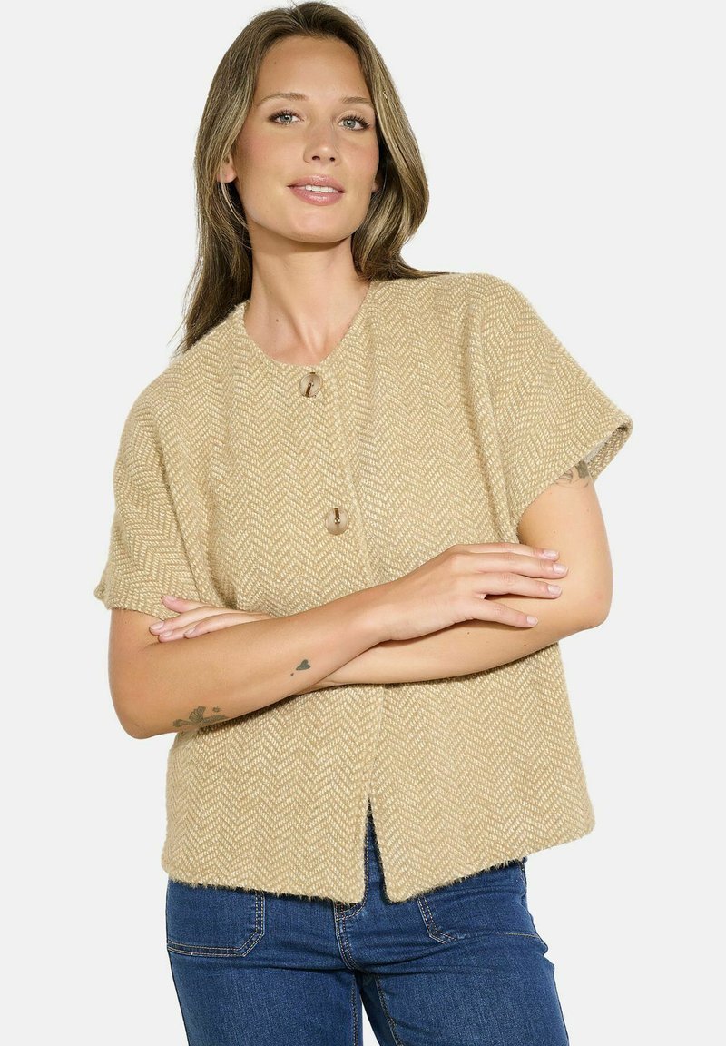 Cardigan beige a maniche corte con motivo a spina di pesce, caratterizzato da due grandi bottoni e una forma leggermente accorciata e ampia.