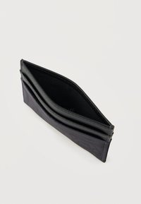 Plāns melns maks atvērts ar tukšu galveno nodalījumu un kartes vietām, izvietots uz vienkārša balta fona.