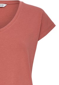 Mäkké bavlnené tričko s krátkym rukávom v tlmenej terakotovej farbe s výstrihom do V a značkovou štítkom vo vnútri goliera.