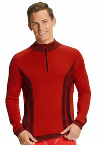 Pull-over en tricot rouge avec un col montant, présentant des accents côtelés noirs et des rayures verticales sur les côtés. Fermeture à glissière sur le devant.