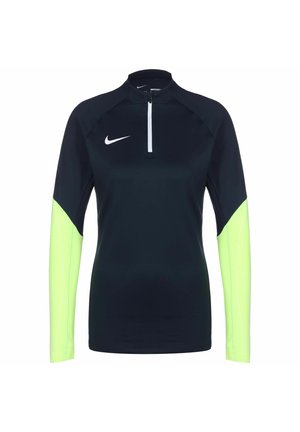 Langemouwen sporttop in donker marineblauw met neon groene mouwen. Beschikt over een hoge kraag en een kwart-rits aan de voorkant. Gemaakt van lichtgewicht, rekbare stof.