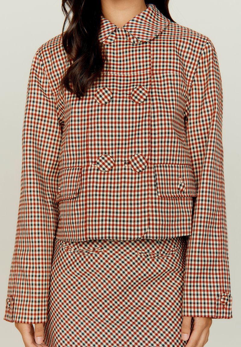 Ruutudega jakk krae jaotusega, kus on segatud punase, pruunika ja valge ruudud, kahekordne eesmine disain ja esipocketid.