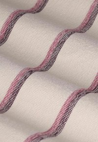 Cremfarbener Stoff mit strukturiertem Gewebe, das wellenförmige horizontale Streifen in Rosa und Schwarz aufweist.