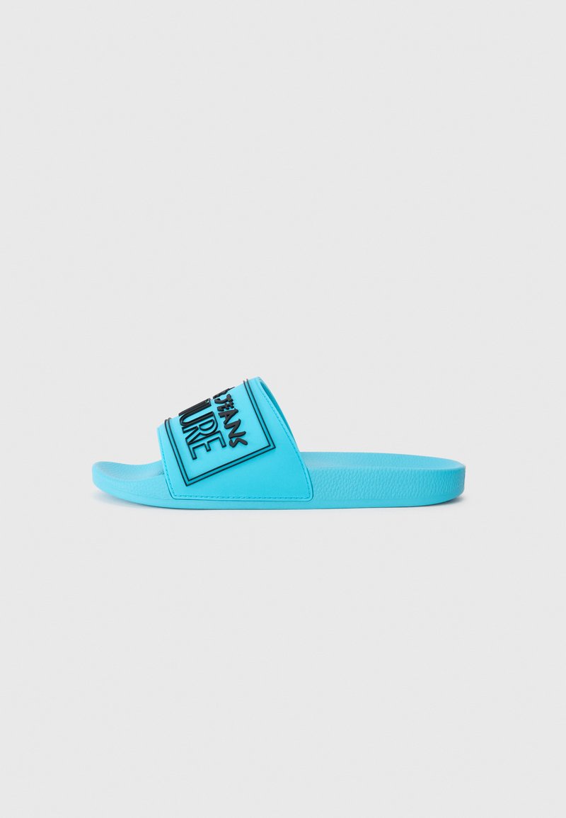 Blue rubber slide sandal with a wide strap featuring black typography. Smooth texture with a flat sole and rounded toe design.