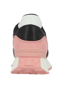 Baskets noires avec un talon rose et blanc. Présente un dessus texturé et une semelle en caoutchouc. Logo "GUESS" embossé sur la section du talon rose.