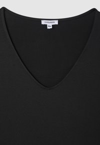 Czarny T-shirt z dekoltem w serek wykonany z miękkiego materiału, o gładkiej fakturze i metce z rozmiarem 2XL. Prosty w designie, bez dodatkowych wzorów.