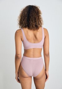 Lys rosa bralette og høyt liv truse-sett. Mykt materiale, sømløst design, og brede stropper for komfort. Synlige søm detaljer.