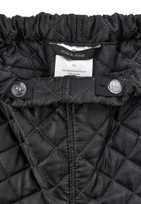 Black quilted polyester garment with a gathered elastic waistband, featuring button closures and a label indicating material and care instructions.