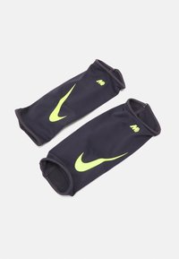 Nike-Ärmel in dunkelblauem Stoff mit gelben Akzenten. Verfügt über eine Mesh-Struktur und ein auffälliges Nike-Logo auf jedem Ärmel.