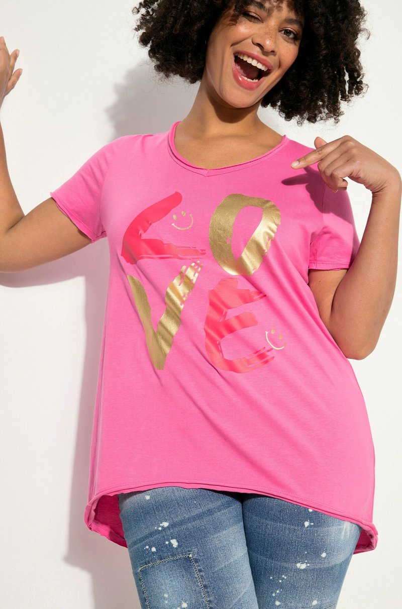Pink short-sleeved T-shirt featuring bold gold and red "LOVE" text with smiley accents, made from soft fabric with a relaxed fit.