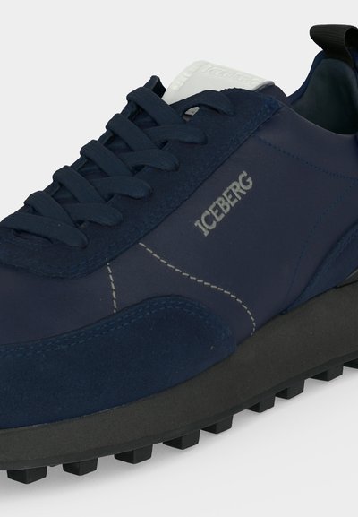 Baskets bleu marine avec semelle noire, semelle extérieure texturée, lacets noirs, étiquette blanche sur la languette et marquage "ICEBERG" sur le côté.