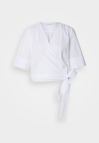 Blouse blanche en coton avec des manches courtes, un col en V et un détail à nouer à la taille. Texture douce et tissu respirant.