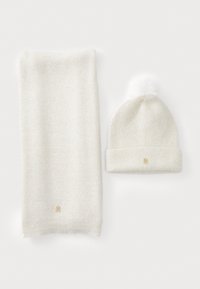 Witte gebreide sjaal en muts set. Sjaal met textuur en een subtiel patroon; muts met een pompon en een klein gouden logo op de manchet.