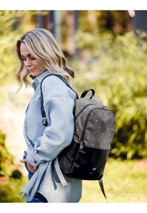 Rucksack aus grauem Stoff mit weißen Punkten, schwarzem Boden, verstellbaren Trägern und einem Handgriff oben. Verfügt über einen Reißverschluss und ein Logodesign.